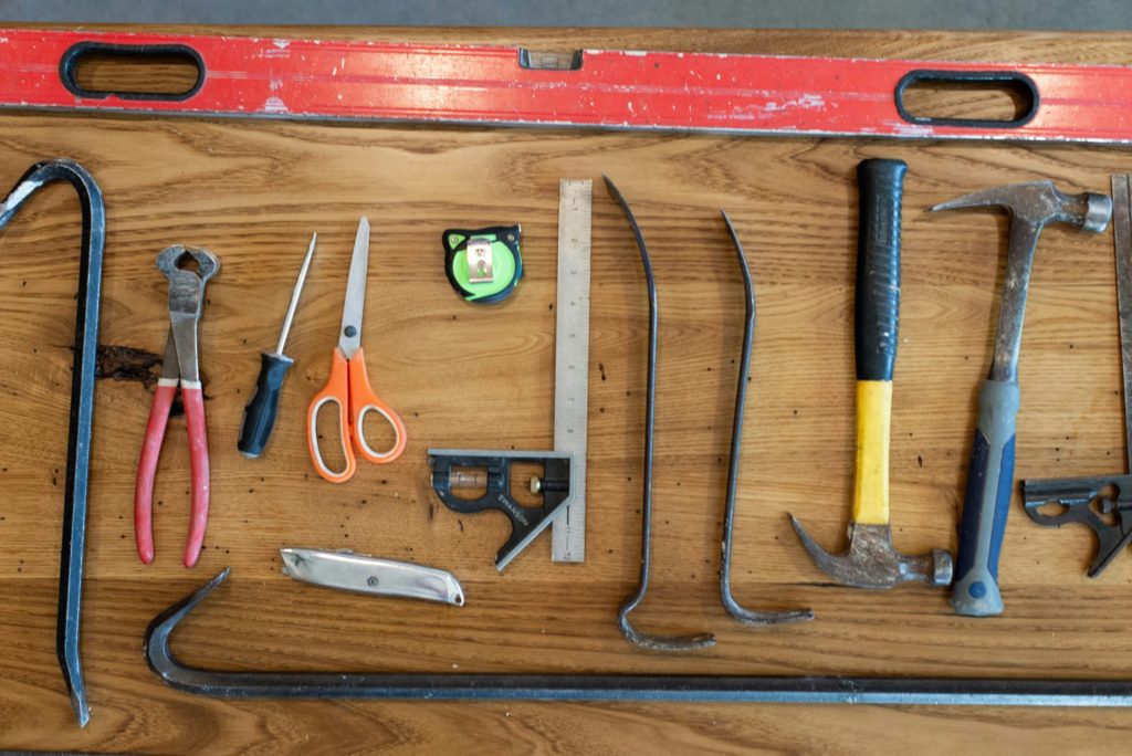 assorted hand tools on brown wooden table